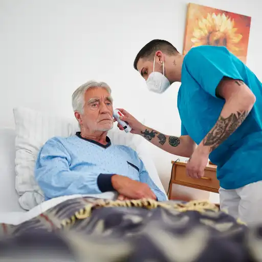 Ein Pfleger kümmert sich um einen Patienten